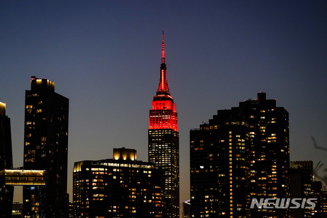 [뉴욕=AP/뉴시스]19일(현지시간) 미국 뉴욕의 엠파이어 스테이트 빌딩 꼭대기에 코로나19 희생자를 추모하는 붉은색 조명이 켜져 있다. 2021.01.20.