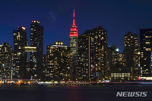 [뉴욕=AP/뉴시스]19일(현지시간) 미국 뉴욕의 엠파이어 스테이트 빌딩 꼭대기에 코로나19 희생자를 추모하는 붉은색 조명이 켜져 있다. 2021.01.20.