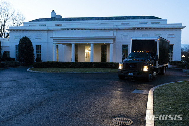 A moving truck drives away from the West Wing of the White House, Wednesday, Jan. 20, 2021, in Washington. (AP Photo/Alex Brandon)