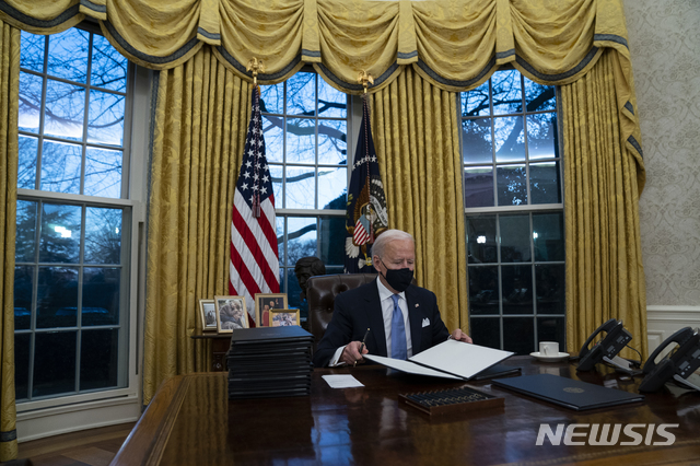[워싱턴=AP/뉴시스] 조 바이든 미국 대통령이 취임을 마친 20일(현지시간) 미국 워싱턴 백악관 집무실에서 행정명령을 살펴보고 있다. 바이든 대통령은 전임인 도널드 트럼프 전 대통령의 서한을 받았다며 "매우 관대한 편지"였다고 평가했다. 2021.1.21.