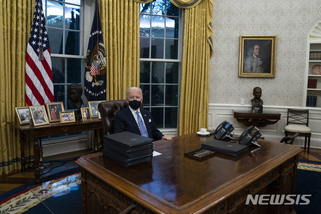 [워싱턴=AP/뉴시스]조 바이든 제 46대 미국 대통령이 취임 첫 날인 20일(현지시간) 백악관 집무실에 앉아 있다. 2021.1.21.