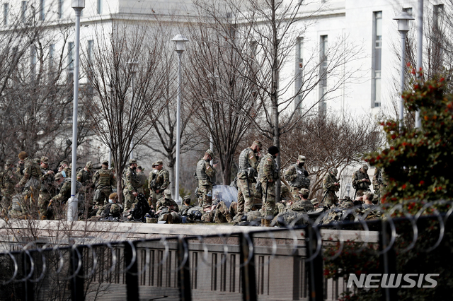 [워싱턴=AP/뉴시스] 조 바이든 대통령 취임식을 앞두고 미 전역에서 동원된 주방위군들이 21일(현지시간) 워싱턴 국회의사당 근처에서 휴식을 취하고 있다. 2021.01.22.