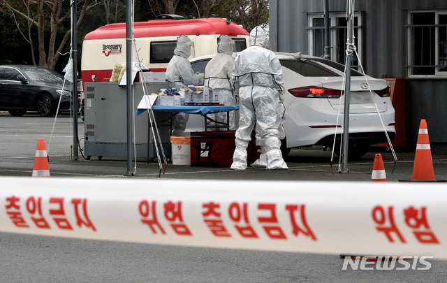 [대구=뉴시스] 이무열 기자 = 대구지역 신종 코로나바이러스 감염증(코로나19) 확진자가 12명으로 집계된 24일 대구 수성구 대구스타디움 제3주차장에 마련된 드라이브스루 코로나19 임시선별검사소에서 의료진이 검체 채취를 하고 있다. 2021.01.24. lmy@newsis.com