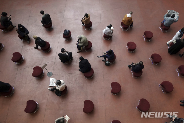 [도쿄=AP/뉴시스]26일 일본 도쿄의 한 공공장소에서 시민들이 코로나19 예방을 위해 사회적 거리를 두고 떨어져 앉아 있다. 2021.01.26.