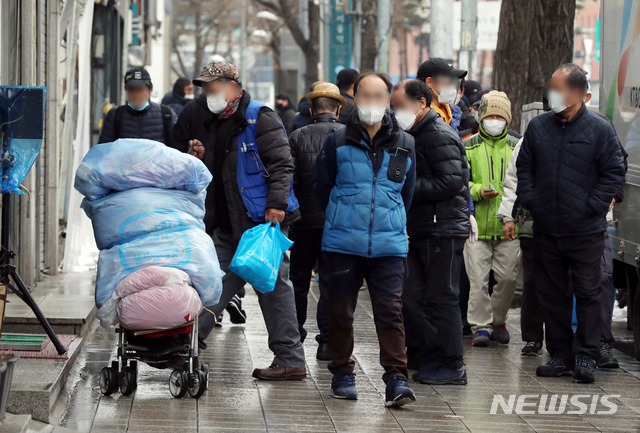 [서울=뉴시스]김병문 기자 = 노숙인들이 28일 오전 서울 용산구 서울역 인근 한 무료급식소 앞에서 배식을 기다리고 있다. 신종 코로나바이러스 감염증(코로나19) 확진자가 발생한 서울역 희망지원센터는 지난 26일부터 운영이 중단되고 있다. 2021.01.28. dadazon@newsis.com