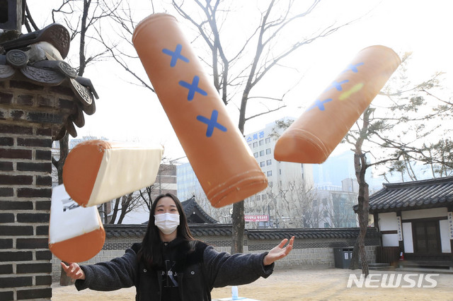 [서울=뉴시스]박민석 기자 = 설 연휴 첫날인 지난 11일 오후 서울 종로구 운현궁에서 한 시민이 윷을 던지고 있다. 2021.02.11. mspark@newsis.com