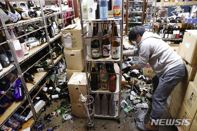 [후쿠시마=AP/뉴시스]14일 일본 후쿠시마에서 한 주류 상점 직원이 전날 밤 지진으로 피해 본 가게를 정리하고 있다. 13일 오후 11시 8분경 후쿠시마현 앞바다에서 규모 7.1의 강진이 발생했지만 쓰나미 위험은 없다고 기상청은 밝혔다. 2021.02.14. 