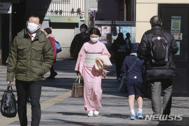 [도쿄=AP/뉴시스]16일 일본 도쿄에서 시민들이 신종 코로나바이러스 감염증(코로나19)를 차단하기 위해 마스크를 쓰고 걸어가고 있다. 2021.02.16.