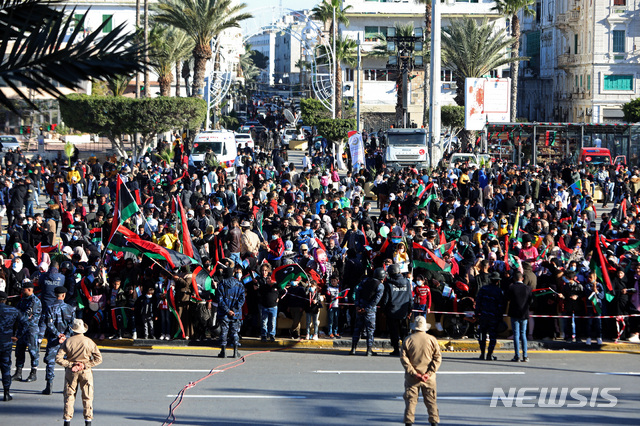 [트리폴리=AP/뉴시스] 10일 리비아 수도 트리폴리에서 아랍의봄 민중봉기 10주년을 맞아 많은 시민들이 엄한 경비 속에 순교자광장에서 국기를 흔들고 축하하고 있다
