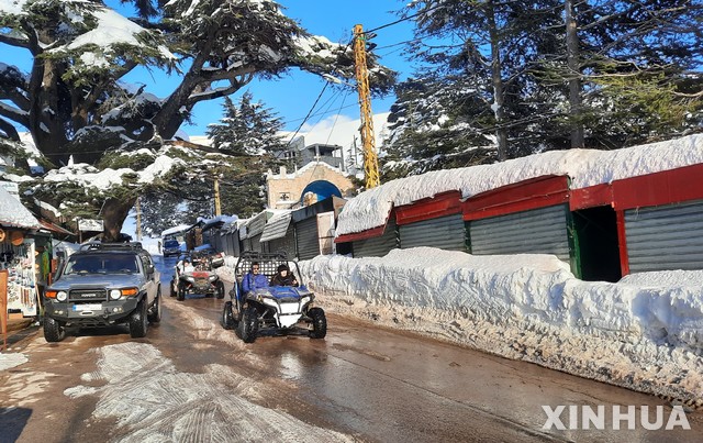 [브샤리=신화/뉴시스]21일(현지시간) 레바논 북부 브샤리(Bsharri)에 폭설이 내린 뒤 한 관광지에서 사람들이 ATV 4륜 바이크를 타고 눈 녹은 도로를 이동하고 있다. 2021.02.22.
