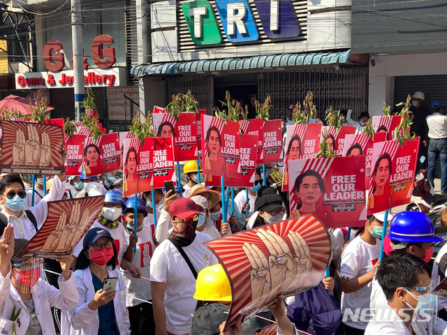 [만달레이=AP/뉴시스]22일 미얀마 만달레이에서 군부 쿠데타 반대 집회가 열려 아웅산 수지 국가고문 얼굴이 있는 팻말을 든 시위대가 행진하고 있다. 미얀마 시민불복종운동은 미얀마 전역에서의 총파업을 촉구하는 시위를 벌이면서 군부는 '무력진압'을 경고하고 있어 대규모 충돌이 우려되고 있다. 2021.02.22.