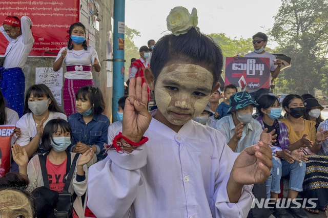 [양곤=AP/뉴시스]지난 2월25일 미얀마 양곤에서 군부 쿠데타 반대 시위대 속의 한 어린이가 얼굴에 미얀마 전통 천연 화장품 '타나카'를 바르고 세 손가락 경례를 하고 있다. 2021.05.27.
