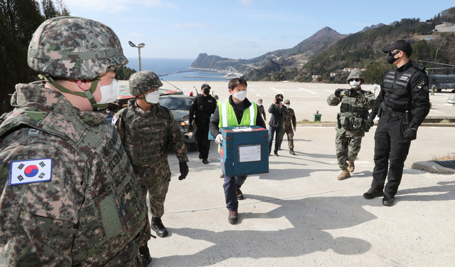 [서울=뉴시스]이영환 기자 = 신종 코로나바이러스 감염증(코로나19) 백신이 28일 공군 시누크(CH-47D) 헬기를 이용해 울릉도 해군부대 헬기장에 도착해 군 장병들의 경계 속에 울릉군보건소로 옮겨지고 있다. (사진=국방부 제공) 2021.02.28. photo@newsis.com *재판매 및 DB 금지