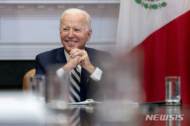 [워싱턴=AP/뉴시스]조 바이든 미국 대통령이 지난 1일 백악관 루즈벨트 룸에서 안드레스 마누엘 로페스 오브라도르 멕시코 대통령과 화상 회담을 하며 웃고 있다. 2021.03.09.