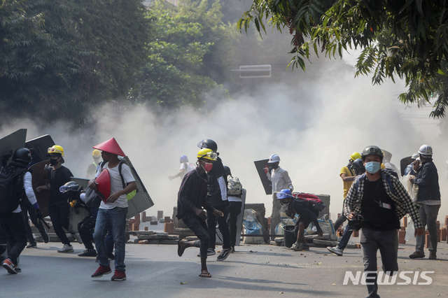 [만달레이=AP/뉴시스]3일 미얀마 만달레이에서 군부 쿠데타에 반대하는 시위대가 군경이 쏜 최루탄을 피해 달리고 있다. 2021.03.03.