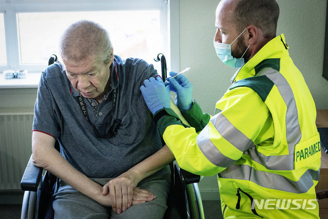 67-year-old Aage Steen Jensen, who is a kidney patient, is vaccinated in his own home in Aalborg, Denmark, Friday, March 5, 2021. People over 65 who receive both practical help and personal care and who cannot be transported to a vaccination site were vaccinated in their homes by paramedics. (Bo Amstrup/ Ritzau Scanpix via AP)