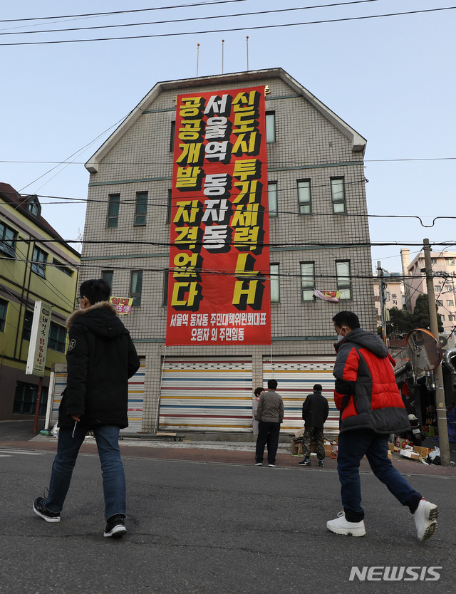 [서울=뉴시스]이영환 기자 = 한국토지주택공사(LH) 임직원의 광명·시흥 신도시 투기 의혹 논란이 지속되고 있는 지난 8일 오후 서울 용산구 동자동 일대 건물 외벽에 공공주택 토지 강제수용 반대 현수막이 걸려있다. 정부는 지난달 5일 동자동 일대 쪽방촌 4만7000㎡를 2410가구가 들어서는 공공주택 단지로 조성한다는 계획을 발표했다. 2021.03.08. 20hwan@newsis.com