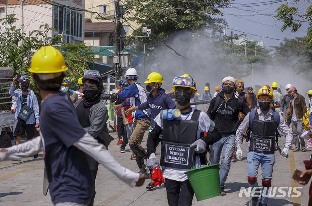 [양곤=AP/뉴시스]10일 미얀마 양곤에서 군부 쿠데타 반대 시위대가 경찰을 향해 소화기를 분출한 후 시위대 일선에서 퇴각하고 있다. 2021.03.10.