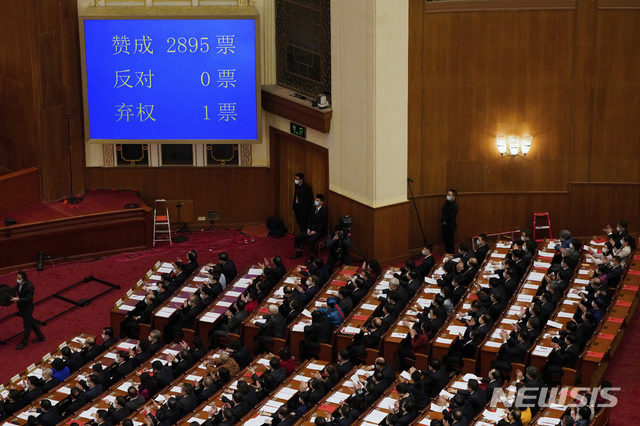 [베이징=AP/뉴시스] 11일 중국 베이징 인민대회당에서 전국인민대표대회(전인대) 폐막식이 열리는 가운데 대형 전광판에 '홍콩 선거 제도 완비에 관한 결의안' 초안, 이른바 홍콩선거법 개정안 표결 결과가 표시돼 있다. 개정안은 찬성 2895표, 반대 0표, 기권 1표로 통과됐다. 2021.03.12