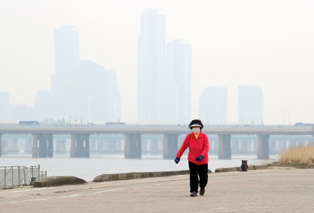 [서울=뉴시스]고승민 기자 = 서울을 비롯한 수도권 지역 미세먼지와 초미세먼지가 '나쁨' 수준을 보인 12일 서울 이촌한강공원에서 마스크를 쓴 한 시민이 산책을 하고 있다. 2021.03.12. kkssmm99@newsis.com 