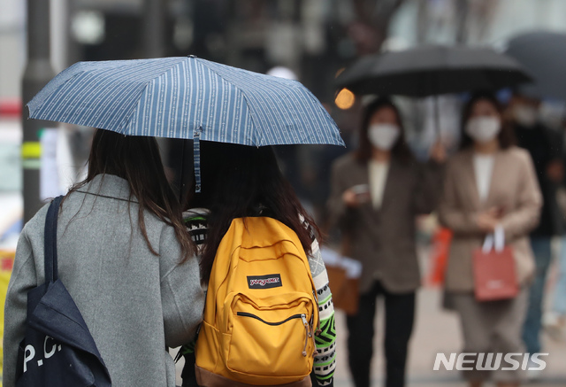[서울=뉴시스]고승민 기자 = 전국에 봄비가 내리기 시작한 지난 3월12일 서울 명동 거리에서 시민이 우산을 쓰고 있다. 2021.03.12. kkssmm99@newsis.com