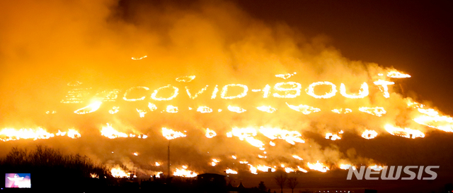 [제주=뉴시스]Reporter Woo Jang-ho = On the afternoon of the 13th, under the theme of 'Wildfire, blooming with hope', the highlight of the 23rd Jeju Wildfire Festival, the oreum bonfire, is taking place in the vicinity of Saebyeol Oreum in Aewol-eup, Jeju-si. Jeju-si engraved 'Wildfire COVID-19 OUT' on the oreum with the hope that COVID-19 will end as soon as possible. 2021.03.13. woo1223@newsis.com