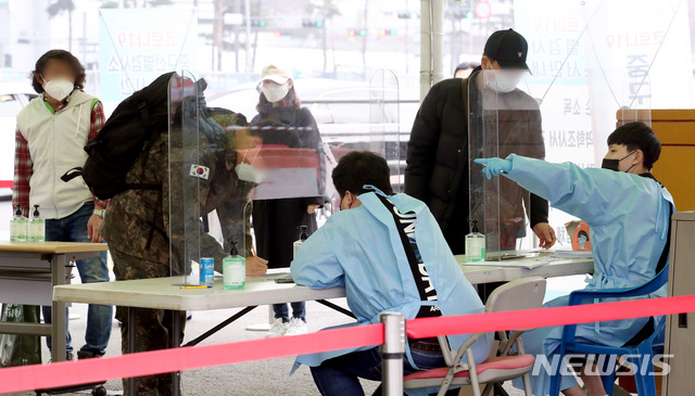 [서울=뉴시스]김병문 기자 = 코로나19 신규 확진자가 7일 만에 300명대로 감소한 15일 오후 서울 용산구 서울역 앞에 마련된 임시선별검사소에서 시민들이 문진표를 작성하고 있다. 2021.03.15. dadazon@newsis.com