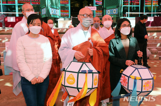 [서울=뉴시스]배훈식 기자 = 대한불교 조계종 총무부장 금곡 스님과 미얀마 청년연대 헤이만씨 등이 16일 오전 서울 종로구 조계사 대웅전 앞에서 미얀마 민주화를 염원하는 연등을 공양하고 있다. 2021.03.16. dahora83@newsis.com