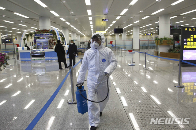 [평양=AP/뉴시스]지난 2월1일 북한 평양공항에서 한 직원이 보호장구를 착용한 채 공항 내를 이동하고 있다. 2021.05.11.