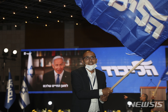 [ 예루살렘 = AP/뉴시스] 지난달 23일 치러진 이스라엘 총선에서 베냐민 네타냐후 총리의 지지자가 출구조사를 앞두고 그의 리쿠드당 깃발을 흔들며 지지를 표하고있다.  2021.04.19