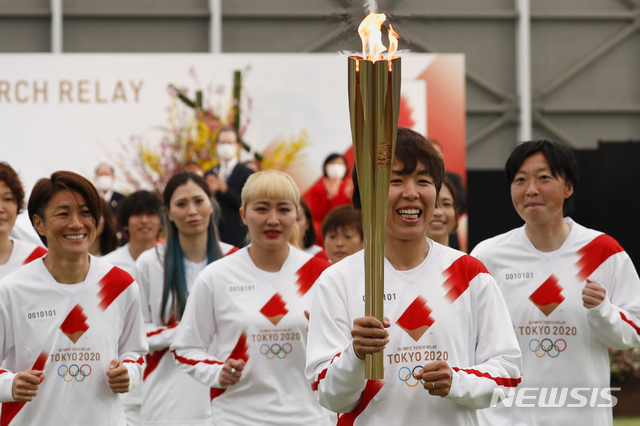 [나라하=AP/뉴시스]3월 일본 후쿠시마현 나라하에서 2011년 당시 일본 여자축구 국가대표팀이 도쿄올림픽 성화 봉송을 하고 있다. 2021.03.25.