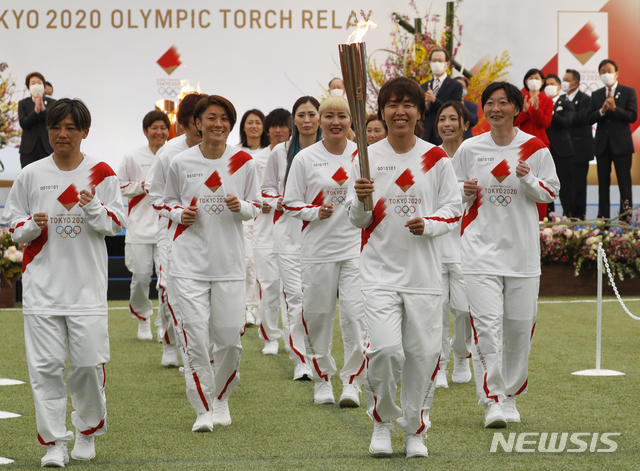 [후쿠시마(일본)=AP/뉴시스]2011년 여자축구 월드컵에서 우승한 일본 여자축구 대표팀 선수들이 25일 일본 후쿠시마(福島)현 J빌리지에서 시작된 도쿄올림픽 성화 봉송의 첫 주자로 나서 성화 봉송 첫 출발을 하고 있다. 도쿄올림픽 성화는 121일 동안 약 1만명의 주자들이 참가한 가운데 일본 47개 현을 돌아 오는 7월23일 국립경기장에 도착할 예정이다. 2021.3.25