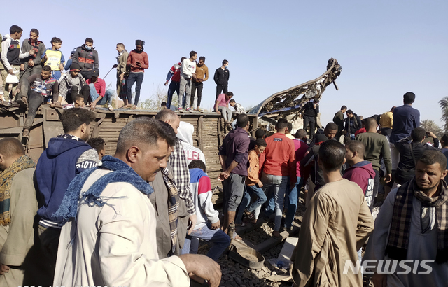 [소하그=AP/뉴시스]26일(현지시간) 이집트 소하그에서 열차 충돌 사고가 나 사람들이 널브러진 객차 주변에 모여 있다. 이집트 보건부는 이 사고로 최소 18명이 숨지고 200명이 다쳤다고 밝혔다. 2021.03.27.