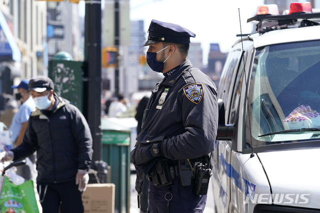 [뉴욕= AP/뉴시스]로드니 히어로 미국 뉴욕경찰국장이 지난 3월30일(현지시간) 뉴욕 퀸즈자치구의 아시아계 거주지역인 플러싱 메인 스트리트 번화가를 따라 보행자와 행상인들을 주시하고 있다. 뉴욕경찰은 아시아계에 대한 증오범죄가 급증하면서 인근 지역 순찰을 강화했다. 2021.05.04.