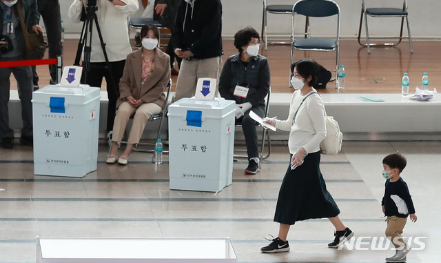 [서울=뉴시스]이영환 기자 = 4·7 재보궐선거 사전투표 시작일인 2일 오후 서울 용산구 서울역에 마련된 남영동사전투표소에서 한 어린이가 어머니와 기표소로 향하고 있다. 2021.04.02. 20hwan@newsis.com