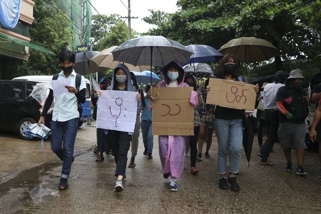 [양곤=AP/뉴시스]지난 6일(현지시간) 미얀마 양곤에서 우산을 쓴 반 쿠데타 시위대가 '빗물 시위'라고 쓰인 팻말을 들고 행진하고 있다. 2021.04.10.
