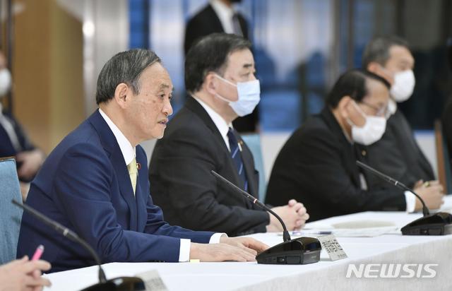 [도쿄=AP/뉴시스]스가 요시히데(왼쪽) 일본 총리가 지난 13일 도쿄 총리 관저에서 열린 각료회의에 참석하고 있다. 2021.04.14.