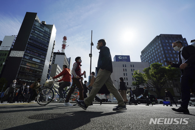 [도쿄=AP/뉴시스]지난 15일 일본 수도 도쿄의 시민들이 코로나19 감염 예방을 위해 마스크를 착용하고 거리를 걷고 있다. 2021.04.16.