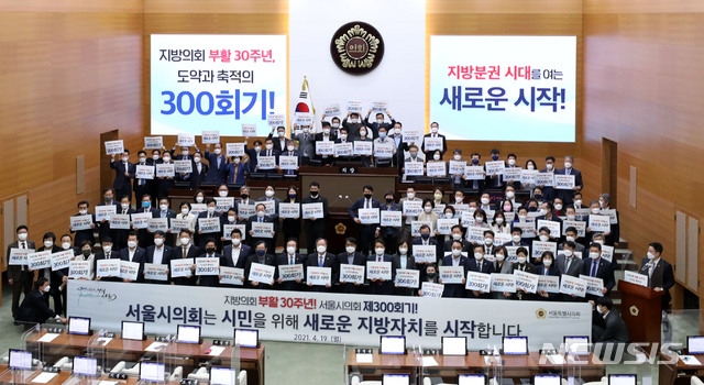 [서울=뉴시스]박주성 기자 = 19일 오후 서울 중구 서울시의회에서 열린 '제300회 시의회 임시회' 기념행사에서 시의회 의원들이 300회 기념 플래카드를 들고 기념촬영을 하고 있다. 2021.04.19. park7691@newsis.com