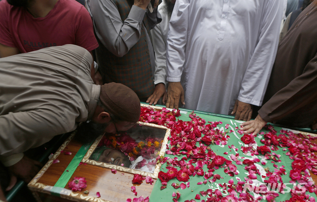 [라호르(파키스탄)=AP/뉴시스]불법화된 파키스탄의 급진 이슬람단체 타흐리크-에-라바이크의 한 지지자가 20일 지난 12일 시위 도중 경찰과의 충돌로 사망한 동료의 관에 입맞추고 있다. 파키스탄 집권당의 암자드 알리 의원이 이날 예지자 무함마드를 풍자한 만평 발간과 관련, 프랑스 대사 추방을 요구하는 결의안을 제출, 하원이 이에 대한 논의를 시작했다. 2021.4.21