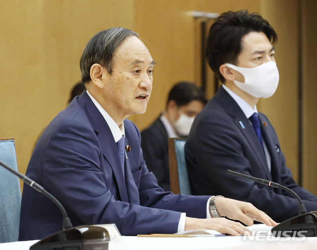 [도쿄=AP/뉴시스]스가 요시히데 일본 총리(왼쪽)가 22일 도쿄 총리실에서 화상으로 열린 세계 기후 정상회의에 참석하고 있다. 스가 총리는 이날 2013년 대비 2030년까지 온실가스 배출량을 46% 감축하고 2050년까지 탄소 중립을 달성하겠다고 밝혔다. 2021.04.22.