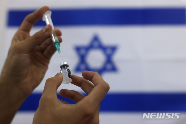 [아시도드=AP/뉴시스]지난 1월7일(현지시간)자 사진에서 이스라엘 군 구급대원이 남부 아스도드의 한 의료센터에서 고령층에 투여할 화이자 코로나19 백신을 준비하고 있다. 2021.06.02.