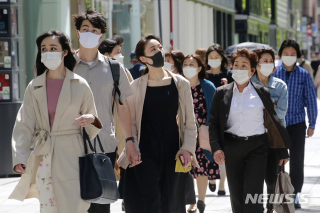 [도쿄=AP/뉴시스] 일본 수도 도쿄의 번화가 긴자에서 26일 코로나19 예방을 위해 마스크를 착용한 시민들이 걸어가고 있다. 2021.04.27 