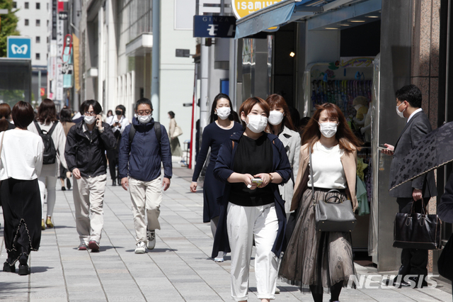 [도쿄=AP/뉴시스]27일 일본 도쿄 거리를 코로나19 감염 방지를 위해 마스크를 쓴 시민들이 걷고 있다. 도쿄에는 코로나19 확산 억제를 위해 긴급사태 선언이 발령된 상태다. 2021.04.27.