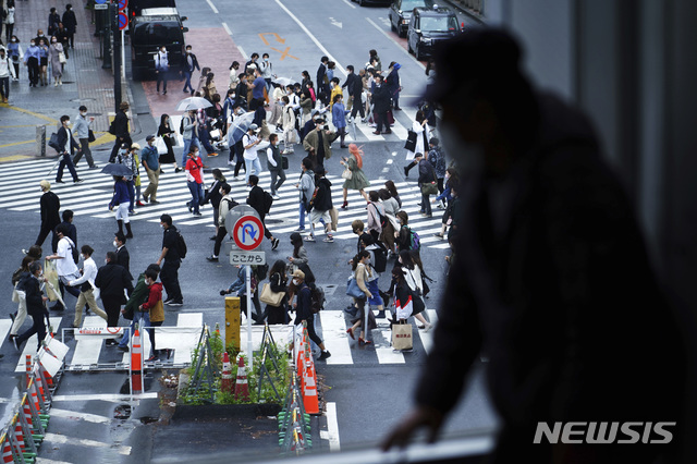 [도쿄=AP/뉴시스]지난달 29일 일본 도쿄 시부야 교차로를 한 남성이 창문 너머로 바라보고 있다. 221.05.03.