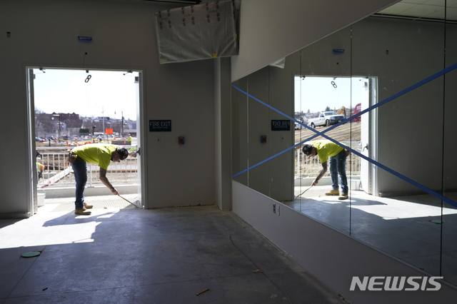 [워체스터(미 매사추세츠주)=AP/뉴시스]지난 3월22일 미 매사추세츠주 워체스터의 레드삭스 트리플A 야구장 폴라파크에서 한 건설노동자가 작업하는 모습이 벽 거울에 비치고 있다. 2021.5.4