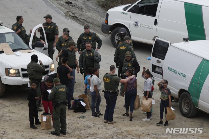 [샌디에이고 =AP/뉴시스] 캘리포니아 샌디에이고 국경관문의 멕시코 쪽에서 불법이민 입국을 단속중인 미 국경수비대가 일부 이민들을 돌려보내고 있다. 최근 이 곳에는 러시아에서 항공기편으로 멕시코에 도착한 많은 러시아 망명신청자들이 몰려들고 있다고 미 국토안보부는 밝혔다.  