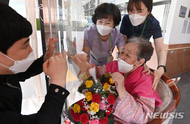 [수원=뉴시스]김종택기자 = 어버이날을 이틀 앞둔 6일 오후 경기도 수원시 장안구 수원보훈요양원에서 입원 환자와 가족이 유리 가림막을 사이에 두고 면회를 하고 있다. 2021.05.06.jtk@newsis.com