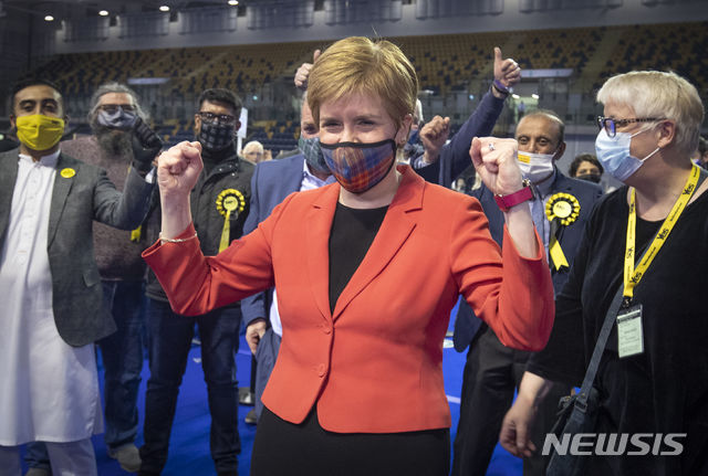 [글래스고(영국 스코틀랜드)=AP/뉴시스]스코틀랜드민족당(SNP) 대표인 니콜라 스터전 스코틀랜드 수서장관이 지난 7일 글래스고에서 하루 전 치러진 의회 선거 개표에서 SNP가 승리할 것으로 나타나자 지지자들과 함께 축하하고 있다. 그녀는 SNP가 4차례 연속 승리한데 대해 "역사적이고 비범한 승리"라고 환영했다. 이번 선거에서 SNP와 녹색당 등 스코틀랜드 독립을 지지하는 정당들이 과반 의석을 얻어 독립에 반대하는 보리스 존슨 영국 총리는 타격을 받게 됐다. 2021.5.9