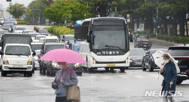 [전주=뉴시스]김얼 기자 = 전북 전주시 덕진구 백제대로에서 우산을 쓴 시민들이 비를 맞으며 발걸음을 재촉하고 있다. 2021.05.10. pmkeul@newsis.com